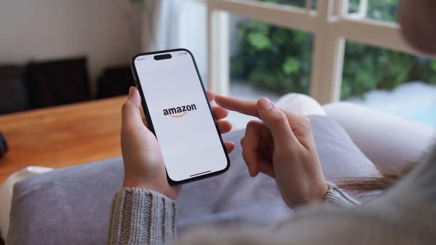 1 What is Amazon Advertising A person using their phone to learn about Amazon advertising.