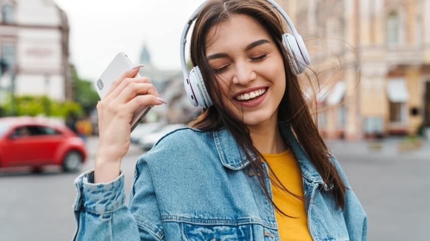 8 Audio Ads 1 A woman smiling and wearing headphones.