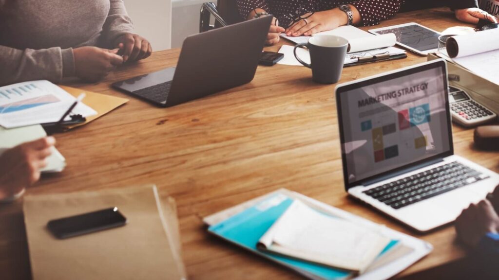 How to sell on Amazon Launch and promote your products A group of people working on developing a marketing strategy.