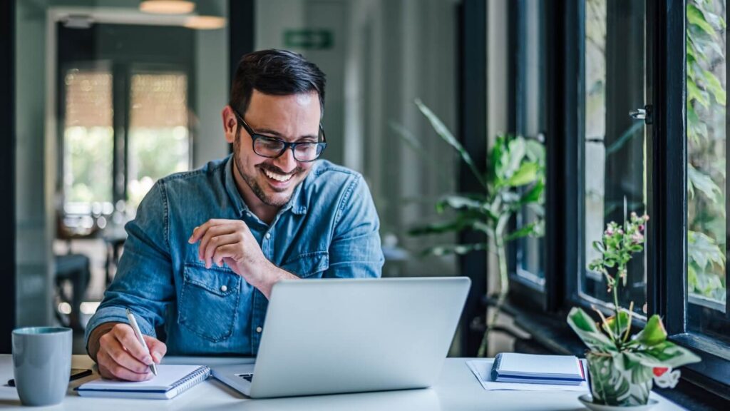 How to sell on Amazon Tips to successfully sell on Amazon A man looking at a laptop screen and smiling.
