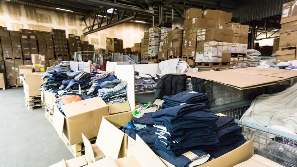 How to sell on Amazon Wholesale A warehouse with various clothing items.