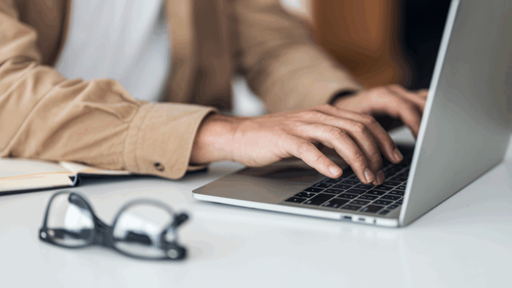 Founders journey or storytelling content A person focused on typing on a laptop computer, with hands positioned on the keyboard.