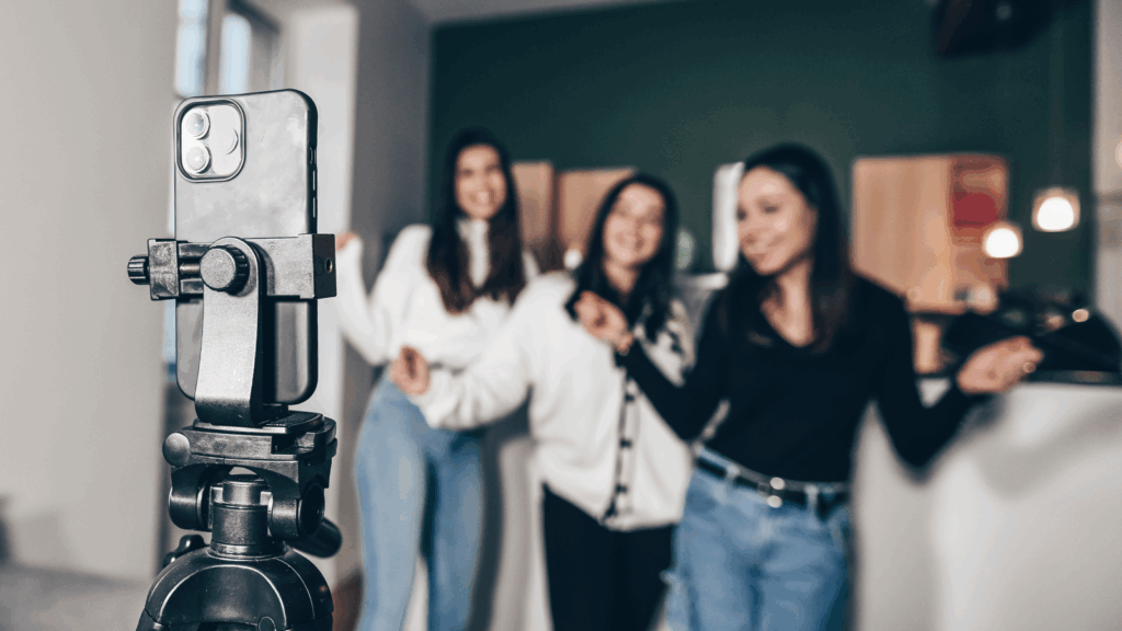TikTok content ideas for businesses Three women stand together, smiling in front of a camera, ready for a photo.