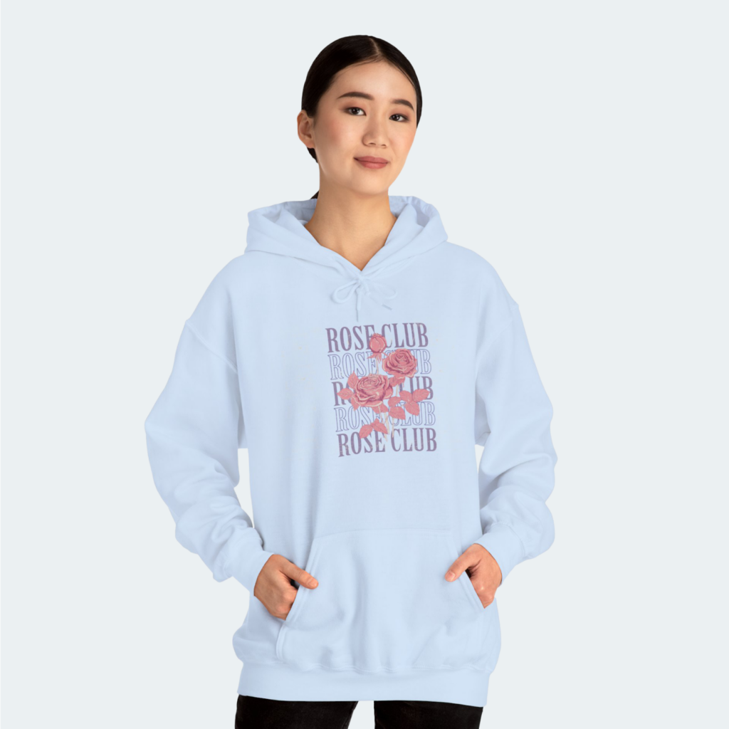 Unisex Heavy Blend™ hooded sweatshirt A woman in a light blue “Rose Club” hoodie against a white background.